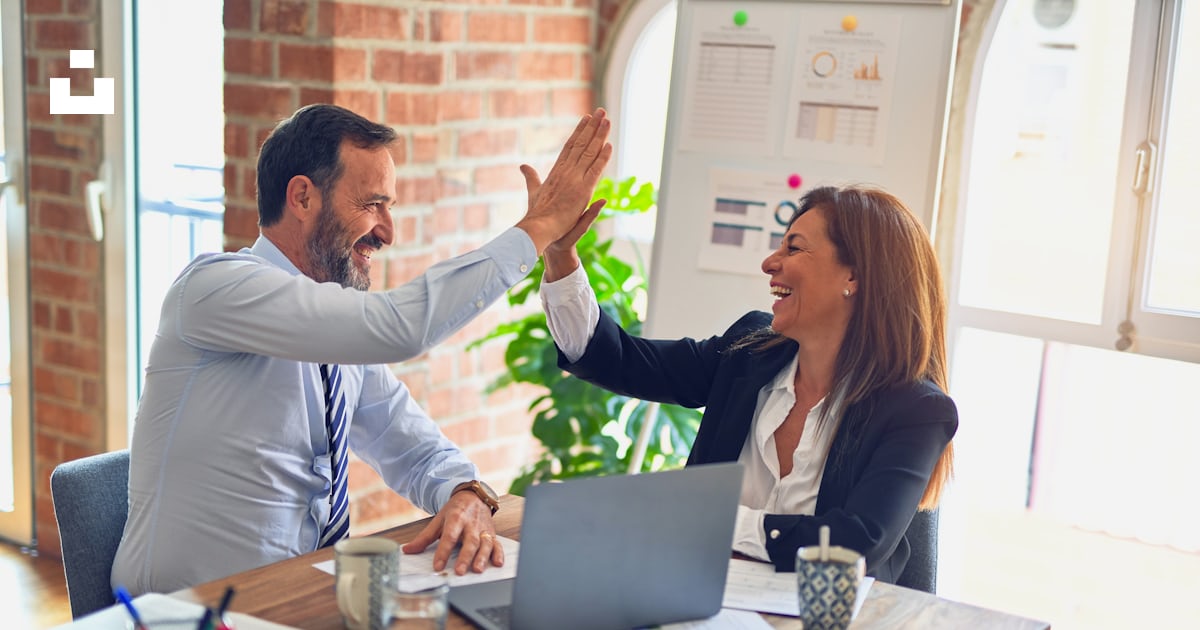 A mentor and founder sharing a high five across a laptop, celebrating progress together