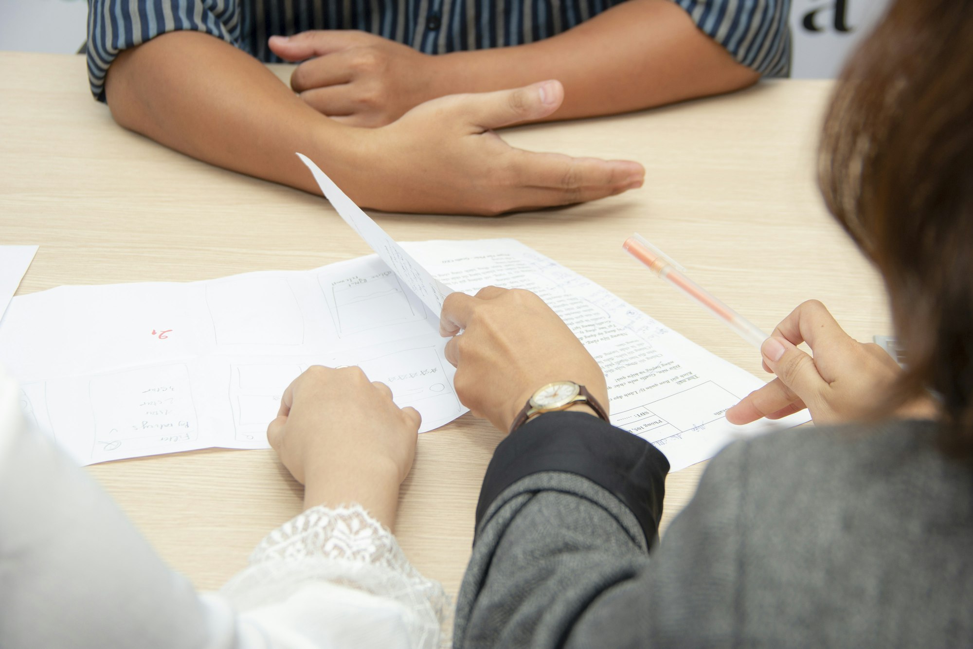 Two people reviewing documents together at a meeting table